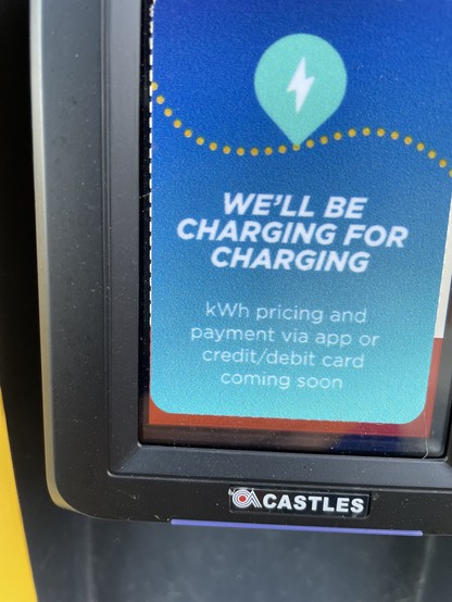 A closeup of what appears to be a credit and debit card machine attached to the charging station says "We'll be charging for charging"
"kwh pricing and payment via app or credit/debit card coming soon"